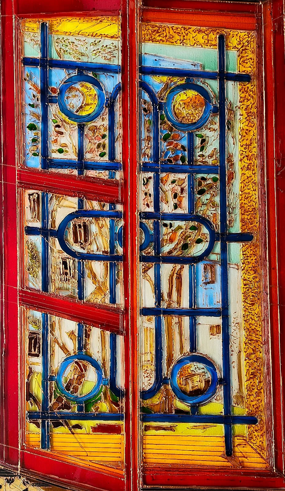 Blue wrought-iron bars and circles lattice a red-framed window, while a sunlit garden and pale stone glow through the panes behind