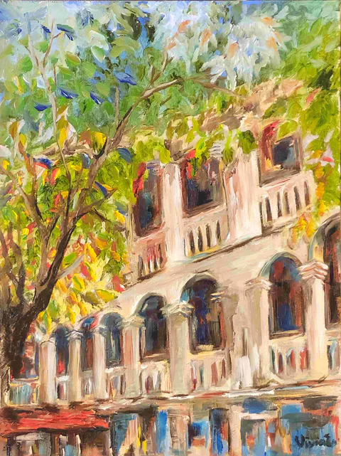 Leafy branches partly screen the sunlit facade of the Institut des Beaux-Arts, with arched windows, pale columns and balconies
